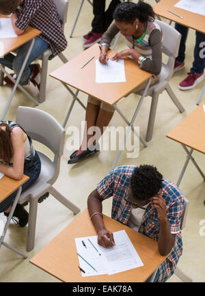 Vista in elevazione del gli studenti scrivono loro GCSE esame in aula Foto Stock