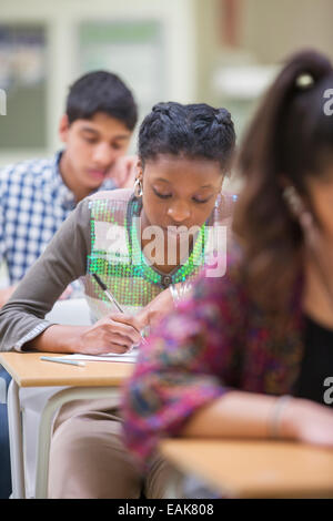 Gli studenti scrivono loro GCSE esame in aula Foto Stock