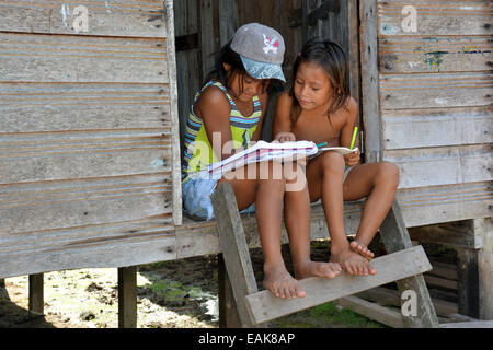 Due ragazze che studiano in un villaggio indiano, seduti sui gradini della loro capanna, Mamirauá-Nationalpark, vicino Tefe, Amazonas Stato Foto Stock