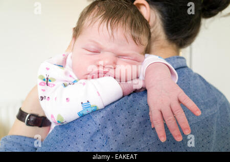 Una settimana di età neonato ragazza addormentata sulla spalla delle madri Foto Stock