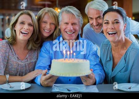 Ritratto di sorridente maturo uomini e donne con torta di compleanno Foto Stock