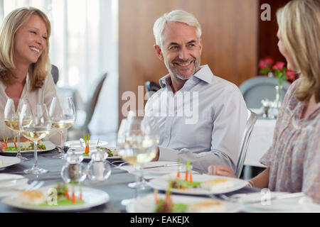 Popolo sorridente godendo il loro pasto in ristorante Foto Stock