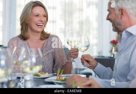 Sorridente donna matura e l uomo la tostatura con vino bianco al ristorante tabella Foto Stock