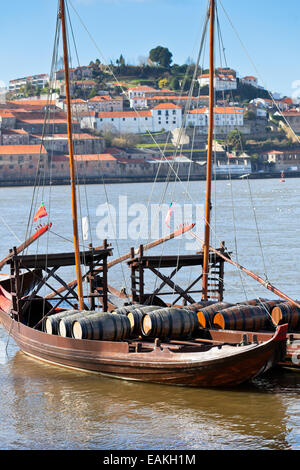 Botti da vino in una vecchia barca in porto. Colpo verticale Foto Stock