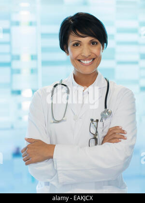Ritratto di sorridere medico donna in piedi con le braccia incrociate Foto Stock