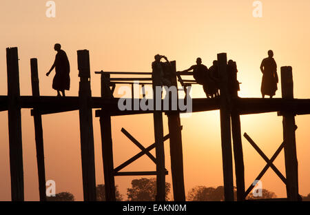 Il tramonto. Attraversamento di U Bein teak ponte sopra il lago Taungthaman, vicino a Mandalay, Myanmar,Birmania,Myanmar Foto Stock