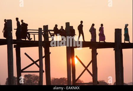 Il tramonto. Attraversamento di U Bein teak ponte sopra il lago Taungthaman, vicino a Mandalay, Myanmar,Birmania,Myanmar Foto Stock