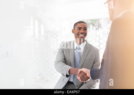 Imprenditori sorridente stringono le mani in office Foto Stock