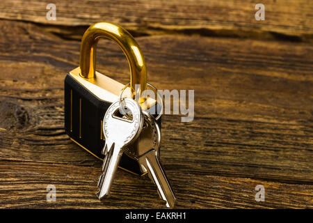 Blocco a cerniera con chiavi su sfondo di legno Foto Stock