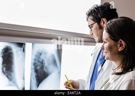 Due medici yound esaminando una pellicola a raggi x al diaphanoscope Foto Stock