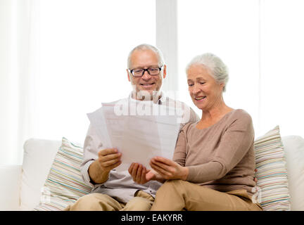 Felice coppia senior con documenti a casa Foto Stock