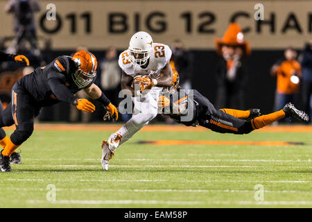 15 novembre 2104: Texas Longhorns wide receiver Daje Johnson (23) viene affrontato da Oklahoma State Cowboys safety Tre fiori (31) e Oklahoma State Cowboys tackle difensivo James Castleman (91) durante il NCAA Football il gioco tra la Oklahoma State Cowboys e la Texas Longhorns a Boone Pickens Stadium di Stillwater, OK. Foto Stock