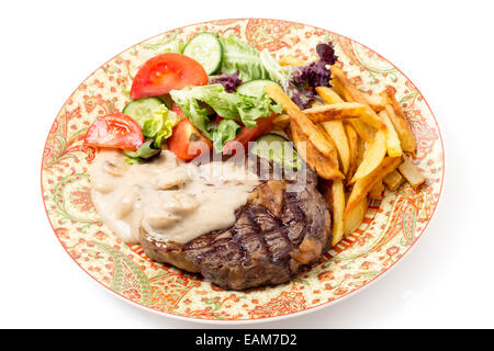 Nervatura alla griglia-eye bistecca di manzo servita con salsa di funghi, insalata e patatine. Foto Stock