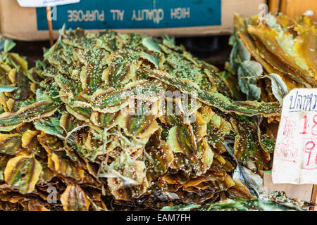 Pesce secco (striscia gialla di carangidi) rivestito con sesamo sulla vendita in un thai street market Foto Stock