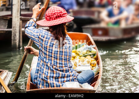 Venditori ambulanti vendono frutta e verdura nel tradizionale mercato galleggiante di Damnoen Saduak vicino a Bangkok, in Thailandia Foto Stock