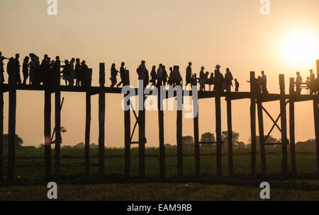 Il tramonto. Attraversamento di U Bein teak ponte sopra il lago Taungthaman, vicino a Mandalay, Myanmar,Birmania,Myanmar Foto Stock