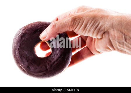 Una mano che tiene una deliziosa ciambella isolate su uno sfondo bianco Foto Stock