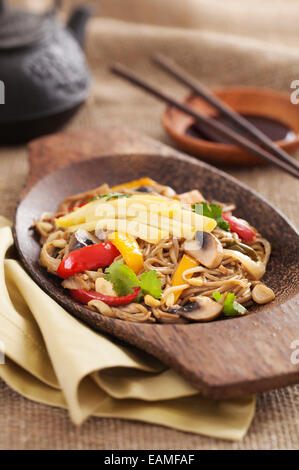 Asian yakisoba noodle con verdure fritte e omelette su di un piatto di legno Foto Stock