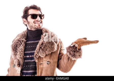 Un giovane uomo che indossa un cappotto di pelle di pecora isolate su uno sfondo bianco Foto Stock