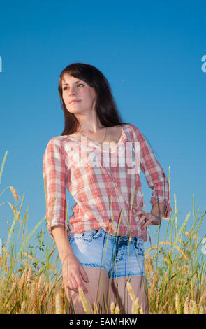 Bella bruna donna in un campo di grano Foto Stock