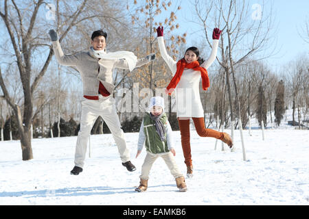 Un bambino famiglie giocare nella neve Foto Stock