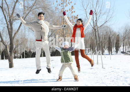 Un bambino famiglie giocare nella neve Foto Stock