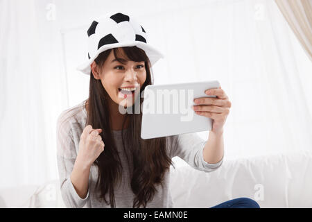 Il cinese fan femminili guarda su un tablet Foto Stock