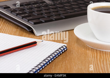 Tastiera, pad e il caffè sul tavolo Foto Stock