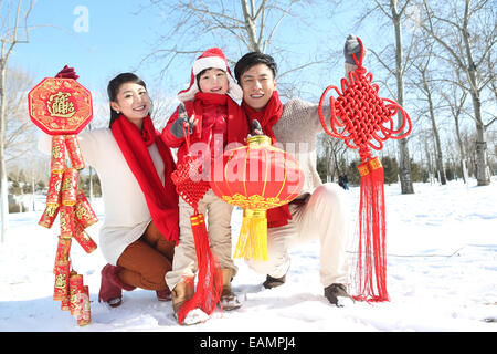 Una famiglia di tre persone nella neve con il nuovo anno decorazione Foto Stock