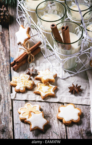 Biscotti di Natale assortiti e bicchieri di latte cocktail serviti con bastoncini di cannella. Foto Stock