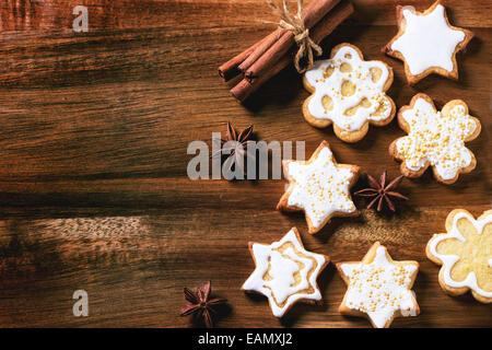 Biscotti di Natale con stelle di anice e bastoncini di cannella sopra lo sfondo di legno. Vista dall'alto. Foto Stock