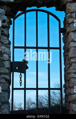 La vecchia porta con griglia in metallo bloccato con una catena Foto Stock