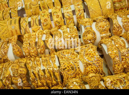 Bracciali in oro sul visualizzatore in corrispondenza di un negozio gioielli al Gold Souk di Dubai, Emirati Arabi Uniti. Foto Stock