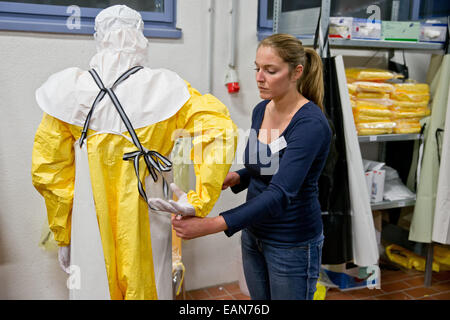 Würzburg, Germania. 03 Nov, 2014. Professionisti della salute Christian Kleine spiega il modo corretto di mettere su abbigliamento protettivo in corrispondenza di un virus di Ebola seminario di formazione in Würzburg, Germania, 03 novembre 2014. Dopo che le forze armate federali, Wuerzberg ha il solo il virus Ebola training center per data. Gli aiuti tedeschi-lavoratori nelle zone di crisi e in tedesco le stazioni di isolamento qui in treno. Foto: DANIEL KARMANN/dpa/Alamy Live News Foto Stock