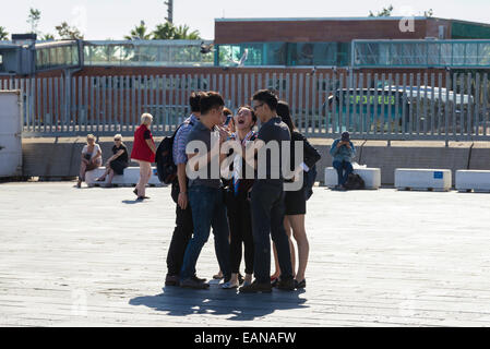 Un gruppo di studenti asiatici avente un buon tempo in Port Vell di Barcellona, in Catalogna, Spagna Foto Stock