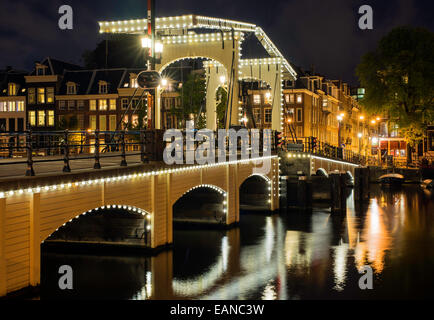 Di Amsterdam Magere Brug o Skinny Bridge, illuminazione notturna Foto Stock