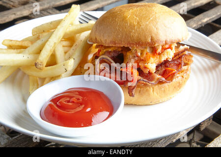 Aragosta principale BLT tomato mayo su una brioche rotolo su una piastra bianca con catchup e patatine fritte e birra Foto Stock
