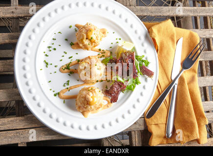 Astice e frittelle di gamberetti con insalata verde su una piastra bianca Foto Stock