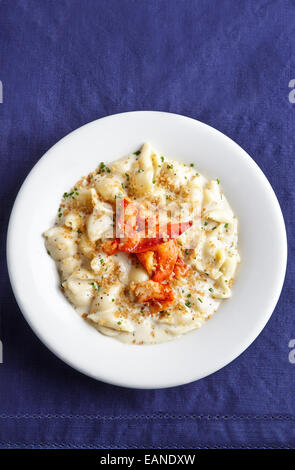 Lobster Mac e formaggio in una piastra bianca con tovagliolo bianco e blu navy tovaglia Foto Stock