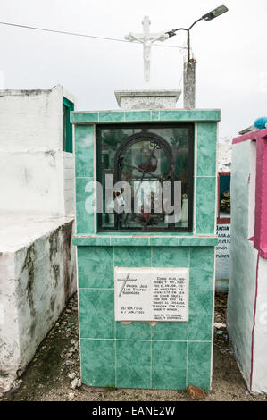 Camera commemorativa con gravi sacrifici, fotografia, immagine di Gesù e un ferro battuto porta ad arco e la croce sulla cima di una tomba piastrellato. Foto Stock