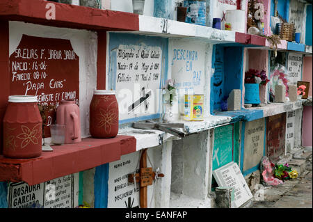 Colorati impilati con tombe dipinte a mano i marcatori di grave e varie offerte di tomba nel cimitero di Champoton, Champoton, Messico Foto Stock