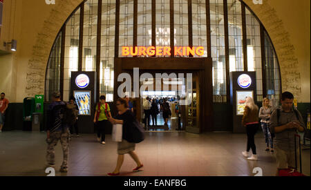 Occupato pendolari a piedi da Burger King ristorante a Helsinki la stazione ferroviaria. Foto Stock