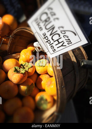 Persimmons organico in un cesto al mercato degli agricoltori di stand in Studio City CA Foto Stock