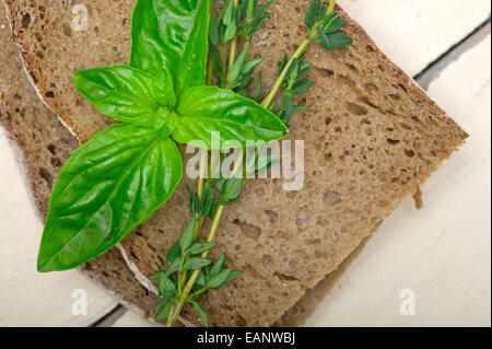 Pane rustico italiano il basilico e il timo semplice spuntino sul bianco tavola di legno Foto Stock