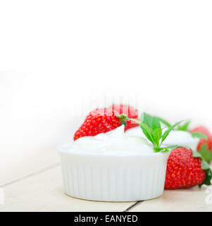 Organici di yogurt greco e fragole bianco su tavola in legno rustico Foto Stock