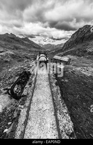 Vecchio e danneggiato ferrovia via utilizzato nelle alpi italiane ad alta quota della costruzione della diga, materiale di trasporto o mining pu Foto Stock