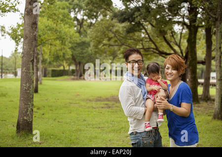 La famiglia in un parco. Due genitori e un bambino. Foto Stock