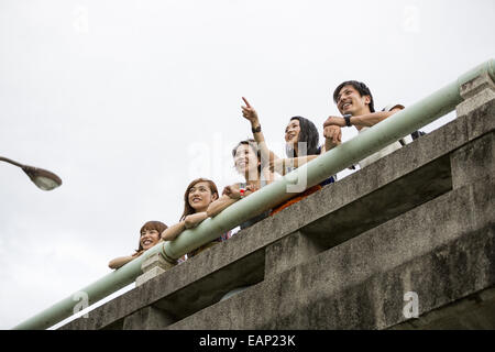 Amici nel parco appoggiato su un parapetto. Vista dal basso. Foto Stock