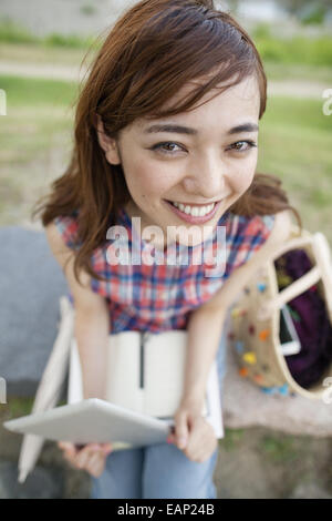 Giovane donna con una tavoletta digitale nel parco. Foto Stock