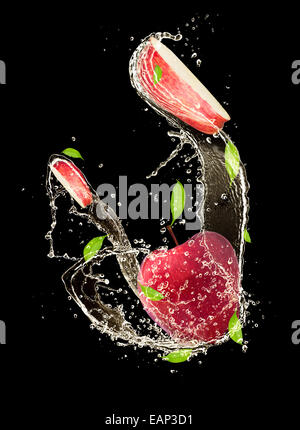 Le mele rosse in acqua splash, isolati su sfondo nero Foto Stock